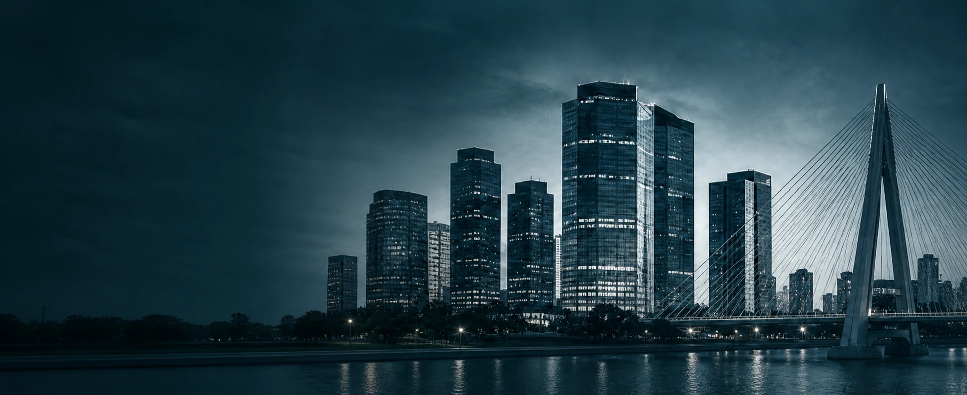 Skyline de edifícios de vidro e ponte estaiada sobre o rio, em tons azul-petróleo